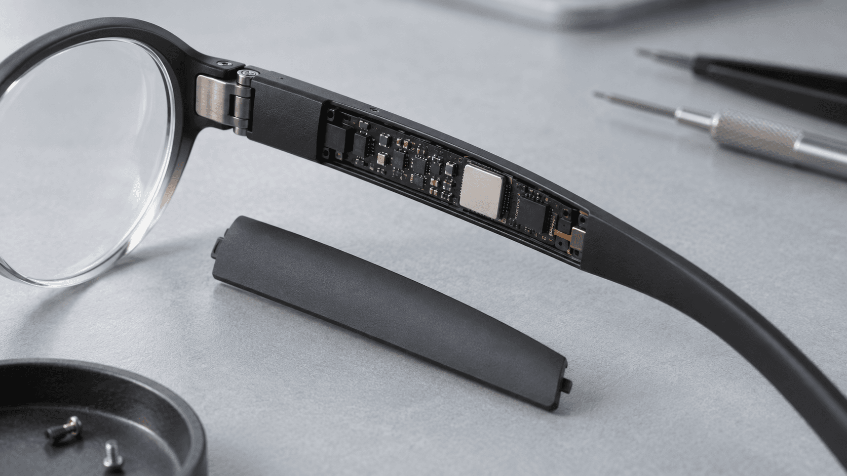 Conceptual studio photograph of an unbranded eyeglass arm with miniature circuitry, not an actual PrismML or Qualcomm product.